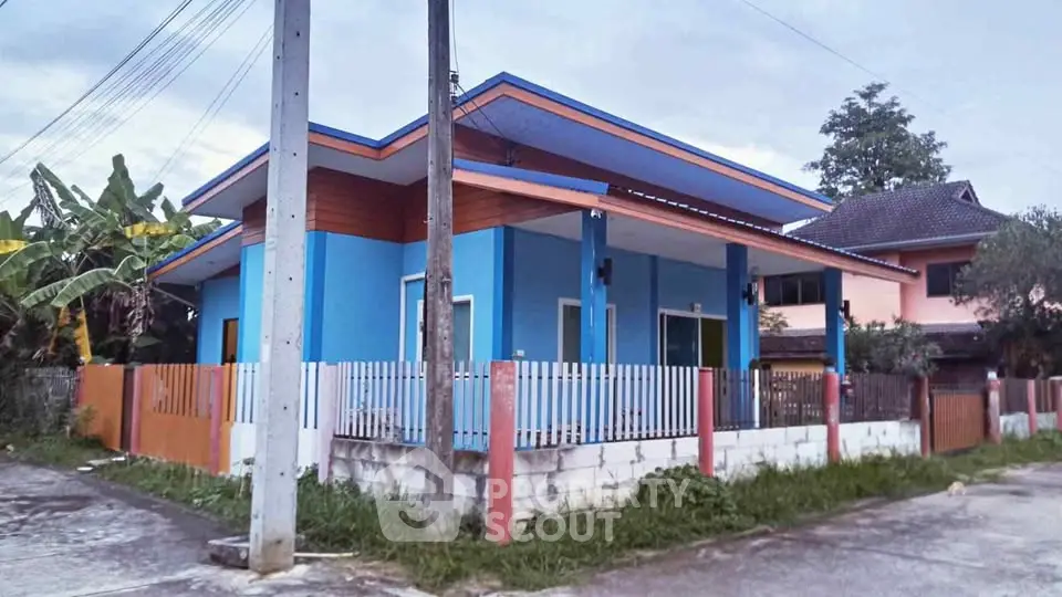 Charming blue house with modern design and fenced yard in a serene neighborhood.