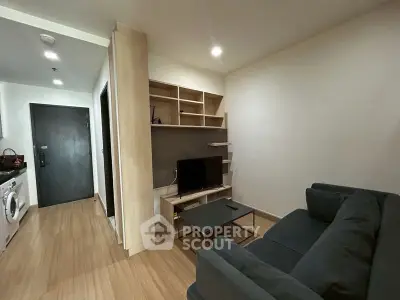 Modern living room with sleek furniture and built-in shelving in a cozy apartment.