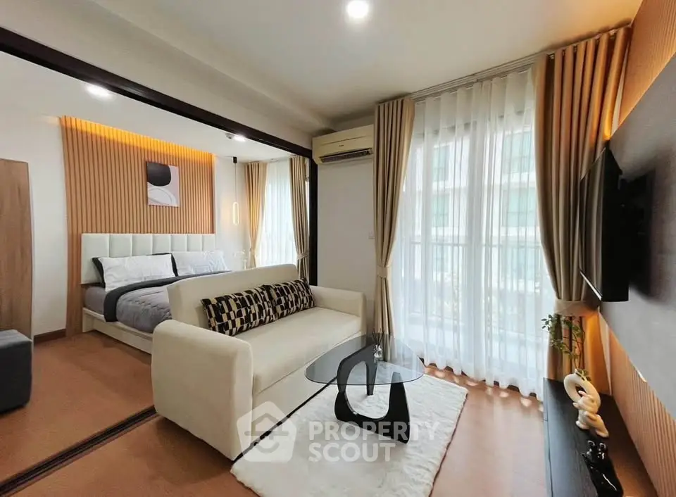 Modern living room with elegant decor and cozy bedroom view, featuring stylish furniture and natural light.