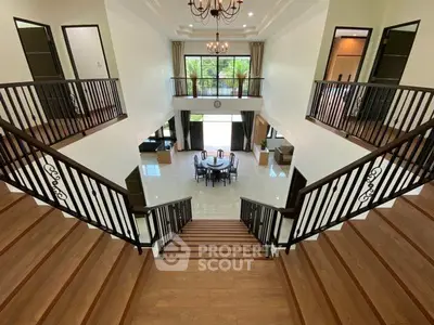 Elegant two-story foyer with grand staircase and open living area, perfect for luxury living.
