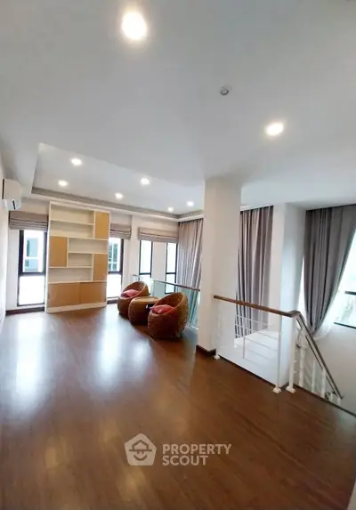Spacious modern living room with elegant wooden flooring and stylish seating area.