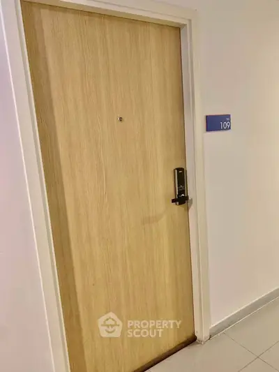 Modern apartment door with electronic lock and room number 109, showcasing secure and stylish entryway.