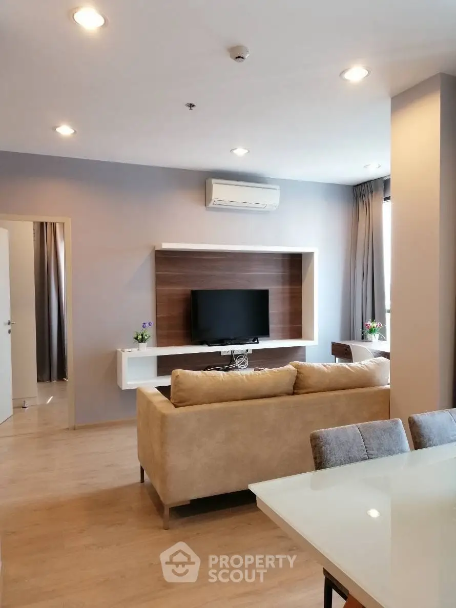 Modern living room with sleek furniture and wall-mounted TV in a stylish apartment.
