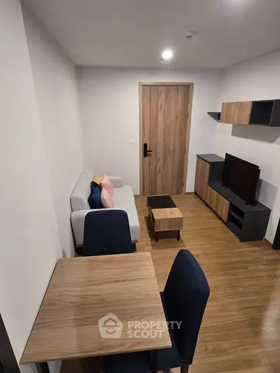 Modern living room with sleek furniture and wooden flooring, perfect for cozy urban living.