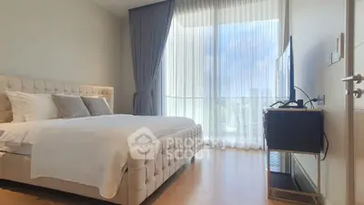 Luxurious bedroom with elegant decor and large windows offering a stunning view.