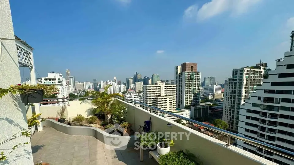 Stunning rooftop terrace with panoramic city skyline views and lush greenery.