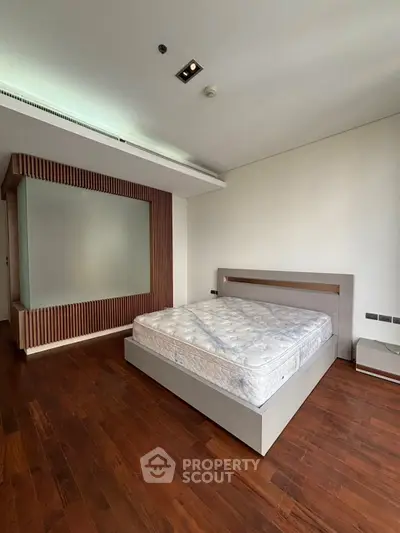 Spacious bedroom with modern design and wooden flooring