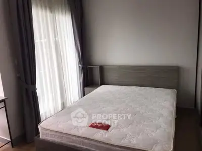 Spacious bedroom with large window and modern bed frame, perfect for natural light lovers.