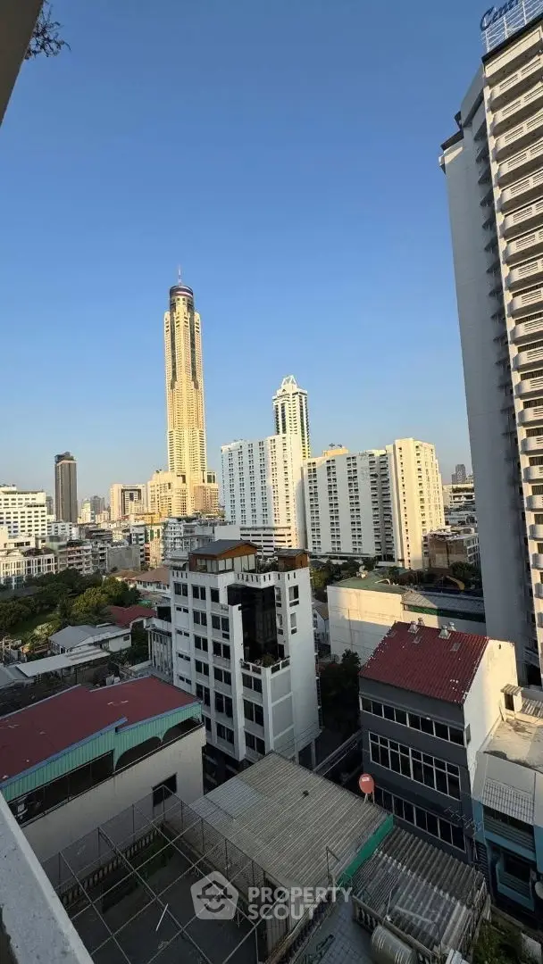Stunning cityscape view from a high-rise balcony overlooking urban skyline and iconic tower.