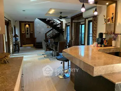 Spacious open-plan living area with modern kitchen and dining space, featuring elegant decor and ample natural light.