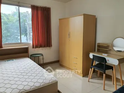 Cozy bedroom with natural light, featuring a bed, wardrobe, and study desk, ideal for comfortable living.