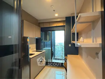 Modern kitchen with sleek design and balcony view in a high-rise apartment.
