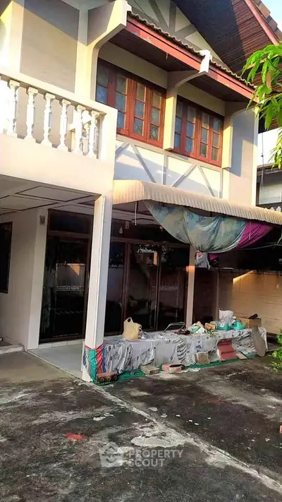 Charming two-story house with balcony and spacious outdoor area, perfect for family living.