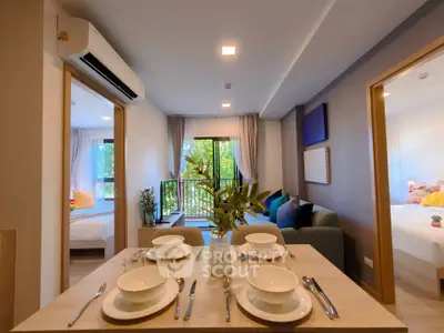Modern open-plan living room with dining area and balcony view in a stylish apartment.