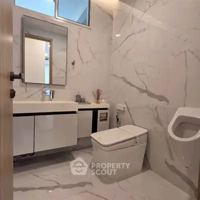 Luxurious modern bathroom with marble walls and sleek fixtures in a high-end property.