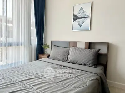 Modern bedroom with stylish decor and large window for natural light.