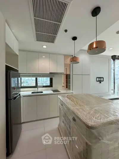 Modern kitchen with sleek white cabinets and island in a high-rise apartment