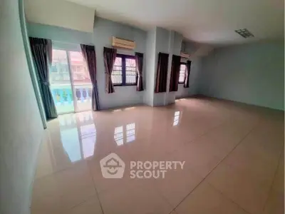 Spacious empty room with large windows and balcony access, ideal for customization.