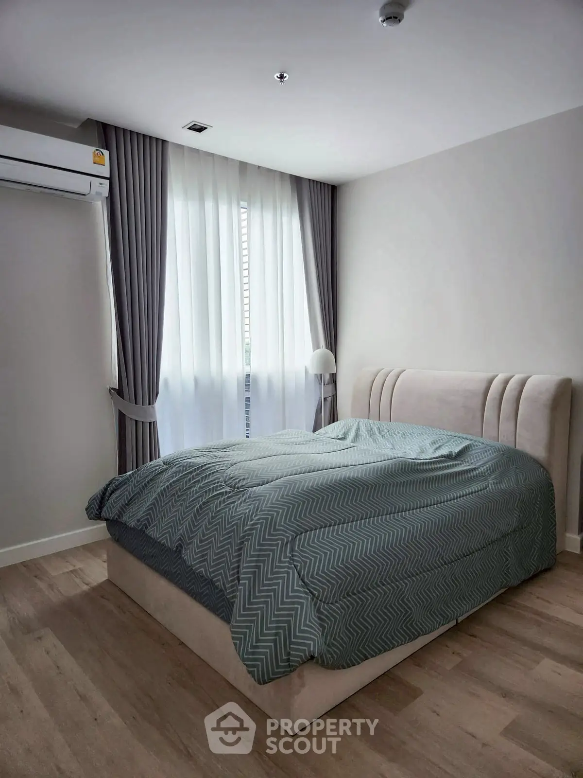 Modern bedroom with stylish bed and elegant curtains in a cozy apartment.