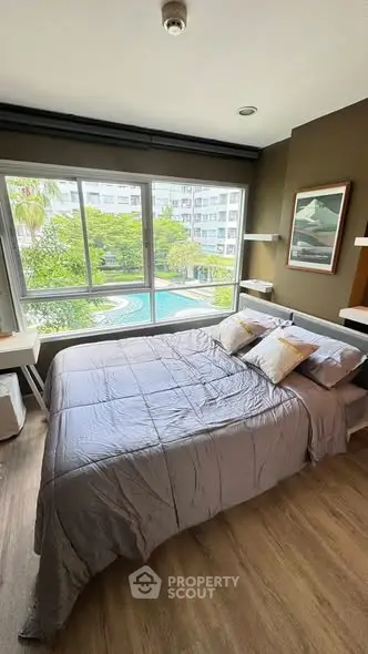 Cozy bedroom with pool view, featuring modern decor and ample natural light.