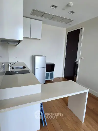 Modern kitchen with sleek design and compact appliances in a stylish apartment.