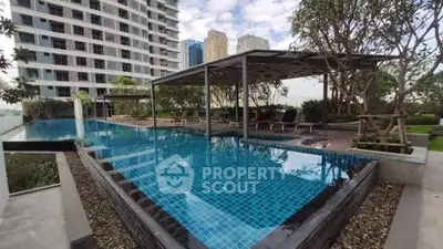 Luxurious rooftop pool with city skyline view in modern residential complex.