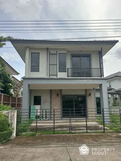 Modern two-story house with sleek design and spacious balcony in a serene neighborhood.