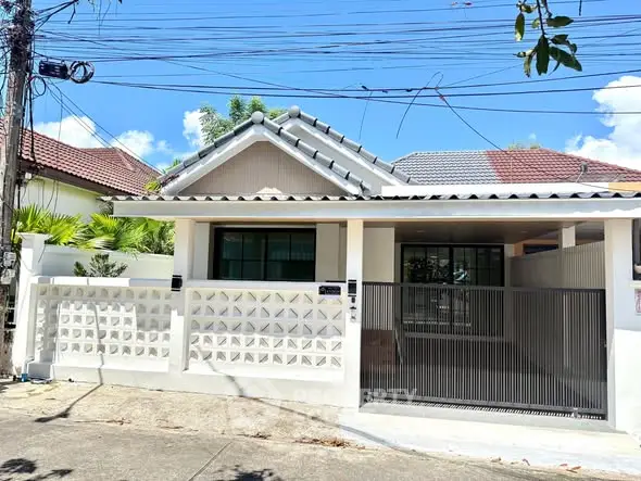 Charming single-story house with modern facade and gated entrance in a serene neighborhood.