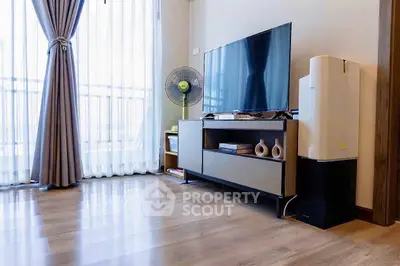 Modern living room with sleek TV stand, large window, and elegant curtains.