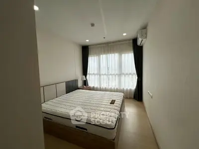 Spacious bedroom with large window and modern furnishings