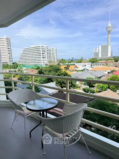 Spacious balcony with stunning city view and modern outdoor seating.