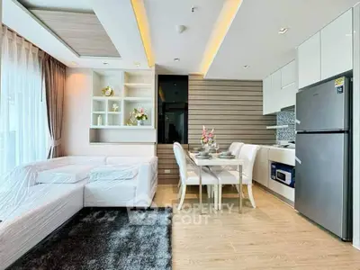 Modern open-plan living room and kitchen with stylish decor and natural light.