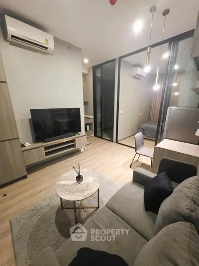 Modern living room with stylish furniture and glass partition, featuring a cozy ambiance.
