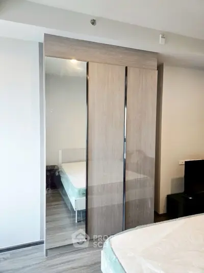 Modern bedroom with sleek mirrored wardrobe and stylish flooring