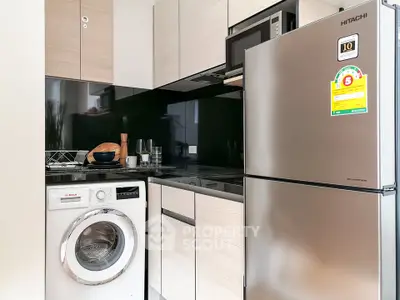 Modern kitchen with stainless steel fridge and washing machine