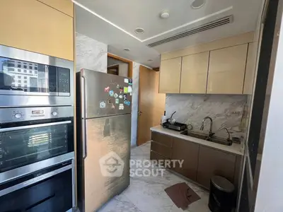 Modern kitchen with sleek cabinetry and stainless steel appliances in a stylish apartment.