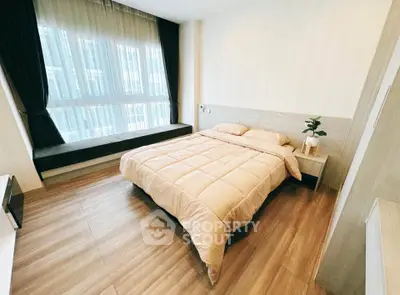 Cozy modern bedroom with large window and stylish decor in a bright apartment.