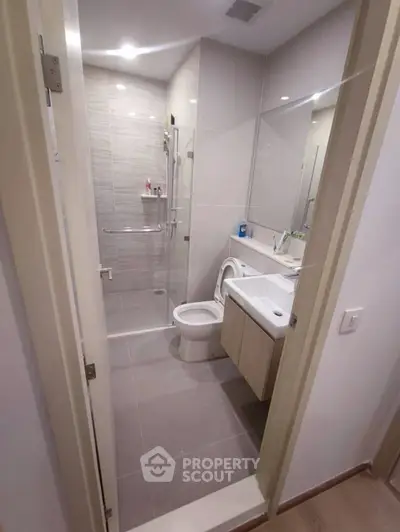 Modern bathroom with glass shower and sleek fixtures in a contemporary apartment.