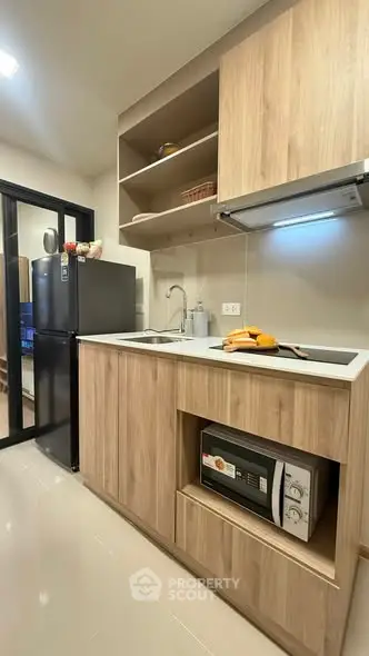 Modern kitchen with sleek wooden cabinets and built-in appliances in a stylish apartment.