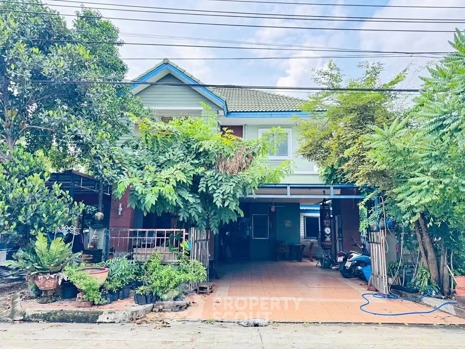 Charming two-story house with lush greenery and spacious driveway