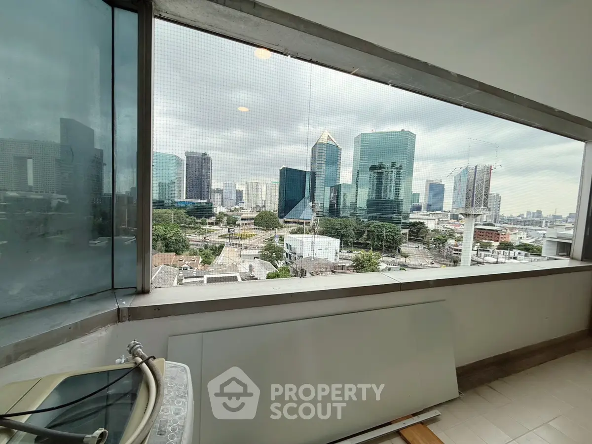 Stunning cityscape view from a modern high-rise balcony with glass railing.