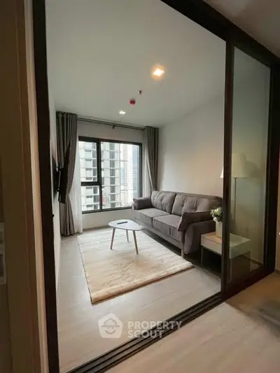 Modern living room with cozy sofa and large window in high-rise apartment