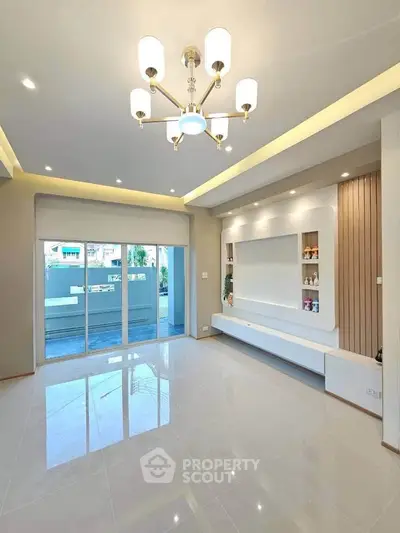 Spacious modern living room with elegant lighting and built-in shelving, perfect for stylish living.