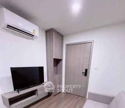 Modern living room with sleek TV unit and air conditioning in a cozy apartment.