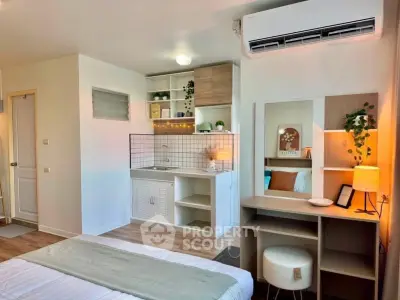 Modern studio apartment with compact kitchen and cozy sleeping area, featuring stylish decor and efficient use of space.