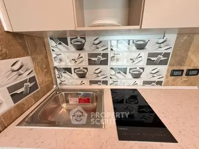 Modern kitchen with sleek induction cooktop and stylish backsplash design.