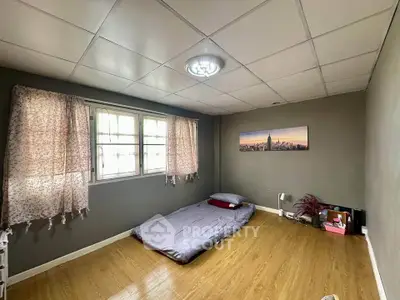 Minimalist bedroom with wooden flooring and cozy bedding, perfect for a serene retreat.