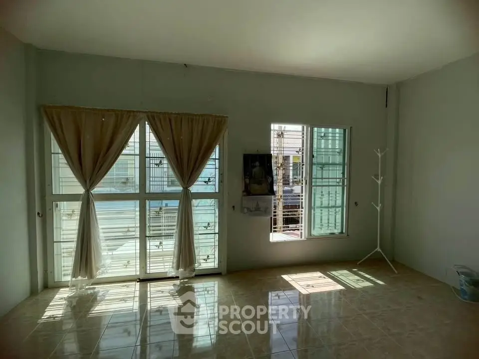 Spacious sunlit room with large windows and tiled flooring, perfect for customization.