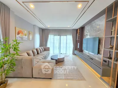 Luxurious living room with modern decor, plush sectional sofa, and large TV setup.