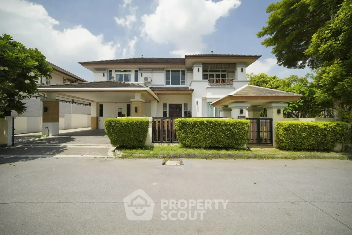 Stunning two-story house with lush greenery and spacious driveway in a serene neighborhood.